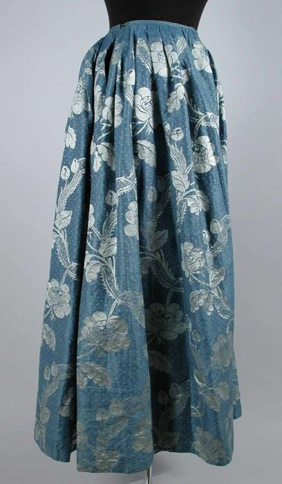 Klooster het laatste geur Collectiestuk: Enkellange wijde rok van blauw zijdedamast met grote  zilvergrijze ingeweven ranken en bloemslingers | Museum Rotterdam