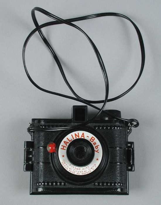 Collectiestuk: Klein fototoestel van zwart kunststof met nekband, | Museum Rotterdam