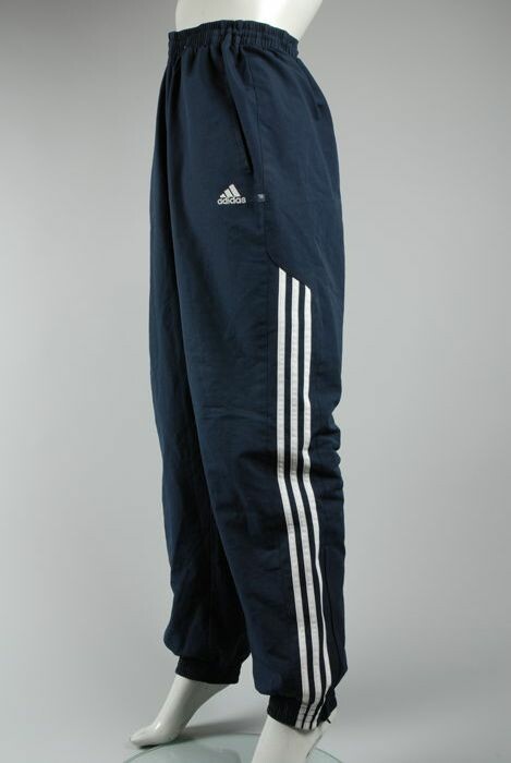 etiquette Miles Absoluut Collectiestuk: Donkerblauwe trainingsbroek van merk Adidas, witte strepen  langs zijkant | Museum Rotterdam
